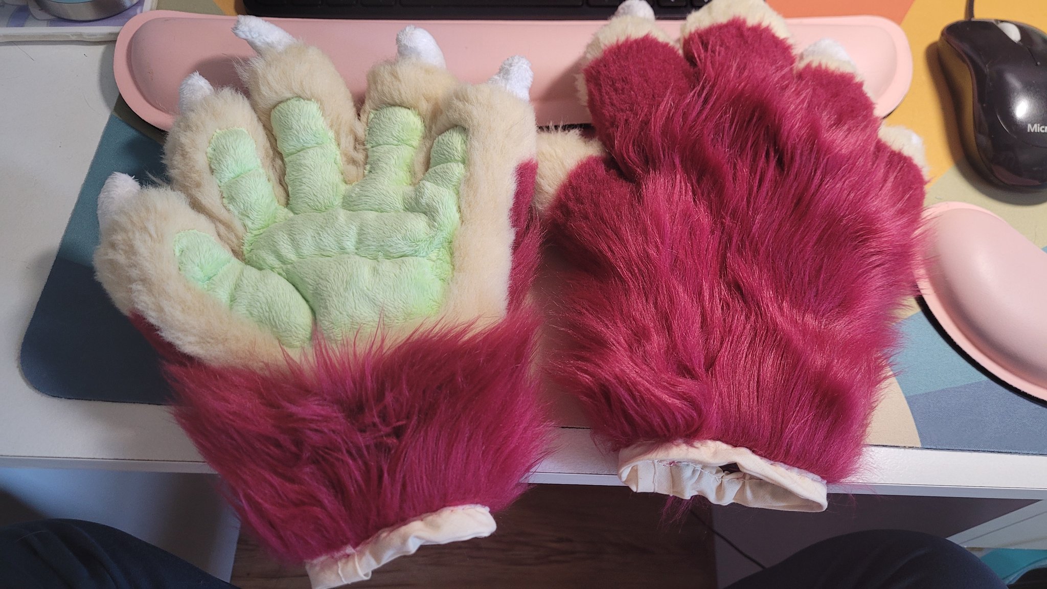 A pair of red, tan and green-coloured fursuit paws