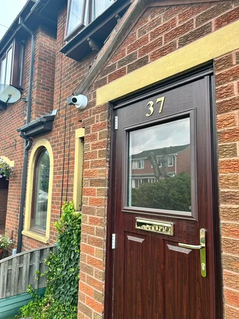 Weatherproof junction box protecting CCTV cable connections on an external wall