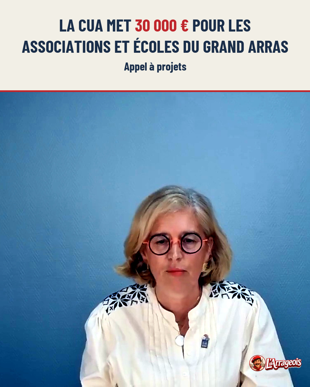 Portrait d'une femme blonde aux lunettes rondes, portant une blouse blanche à épaules brodées, devant un fond bleu uni.