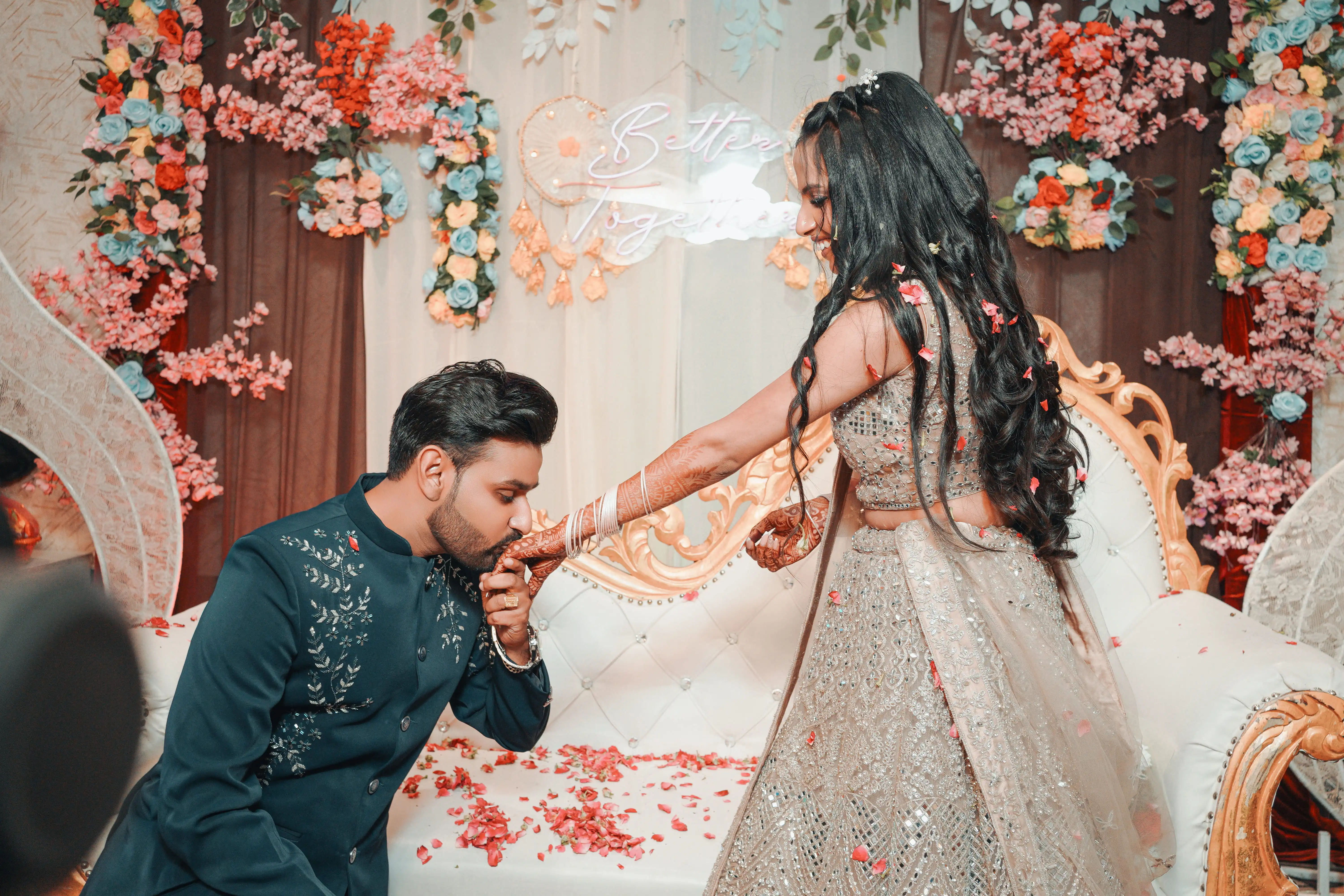 Best Wedding Photography in Ludhiana — Indian bride and groom exchanging garlands under a floral mandap arch decorated with roses and marigolds