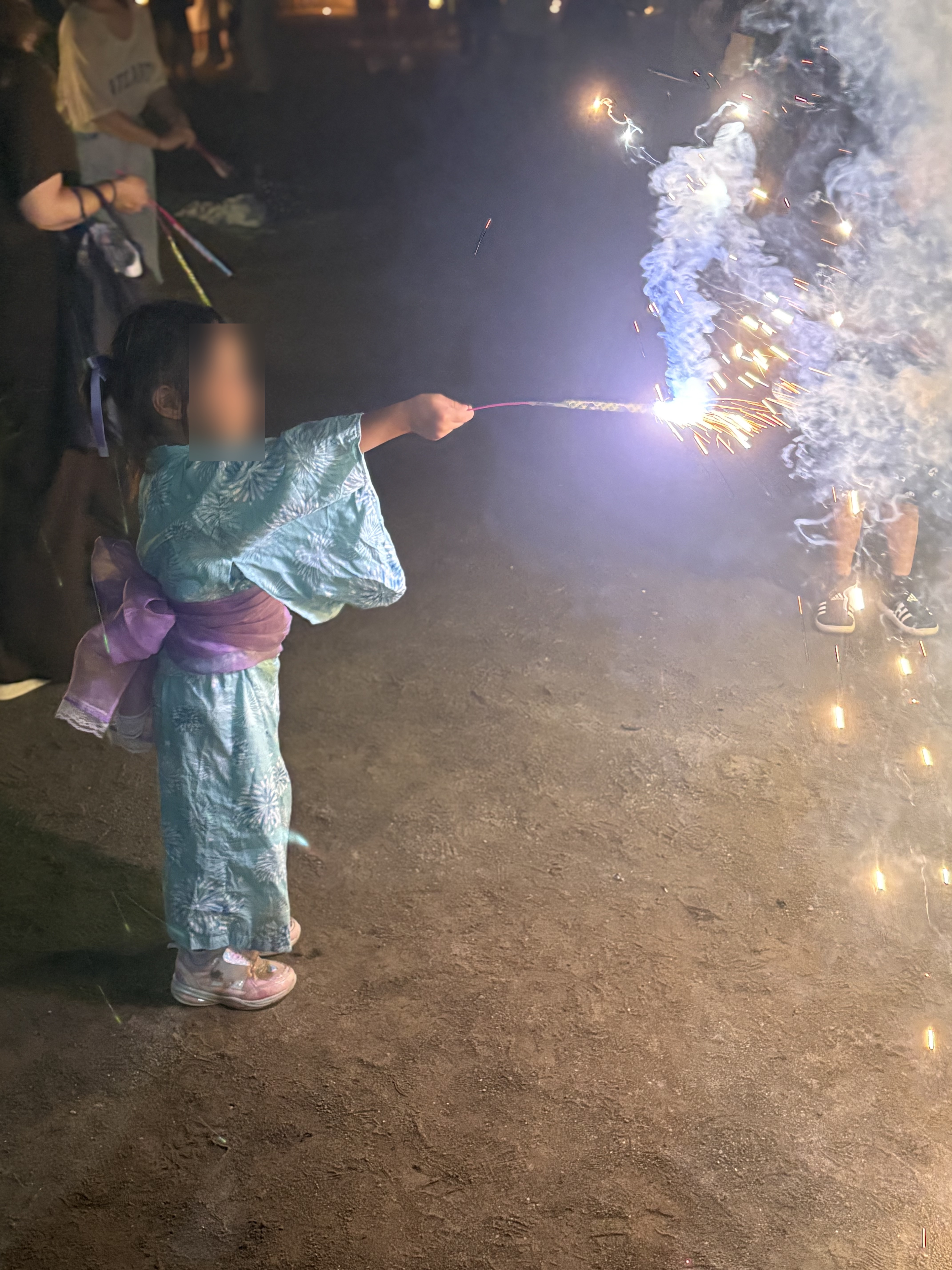 浴衣の女の子が手持ち花火をしている様子
