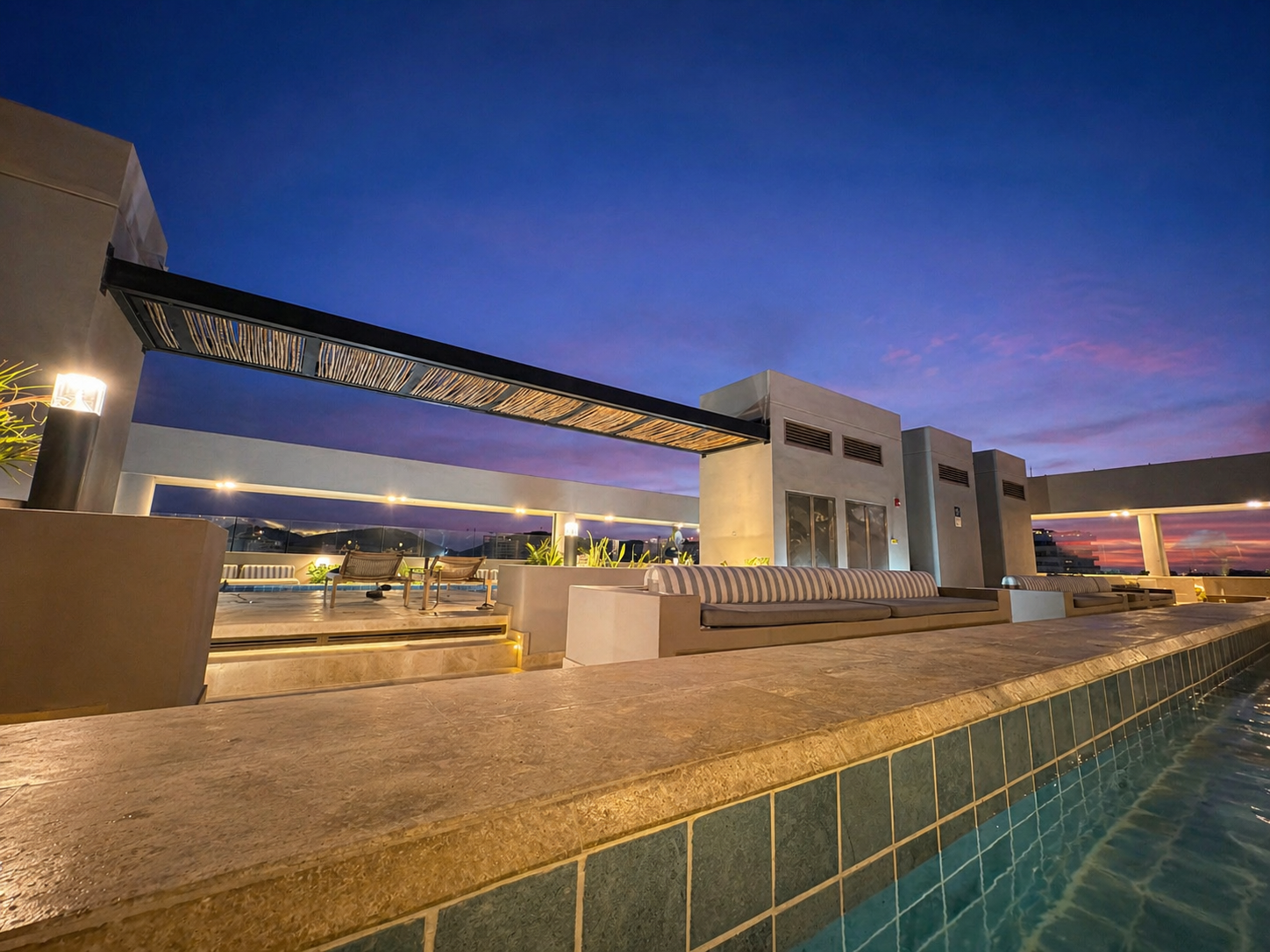 Piscina y terraza rooftop iluminada de noche