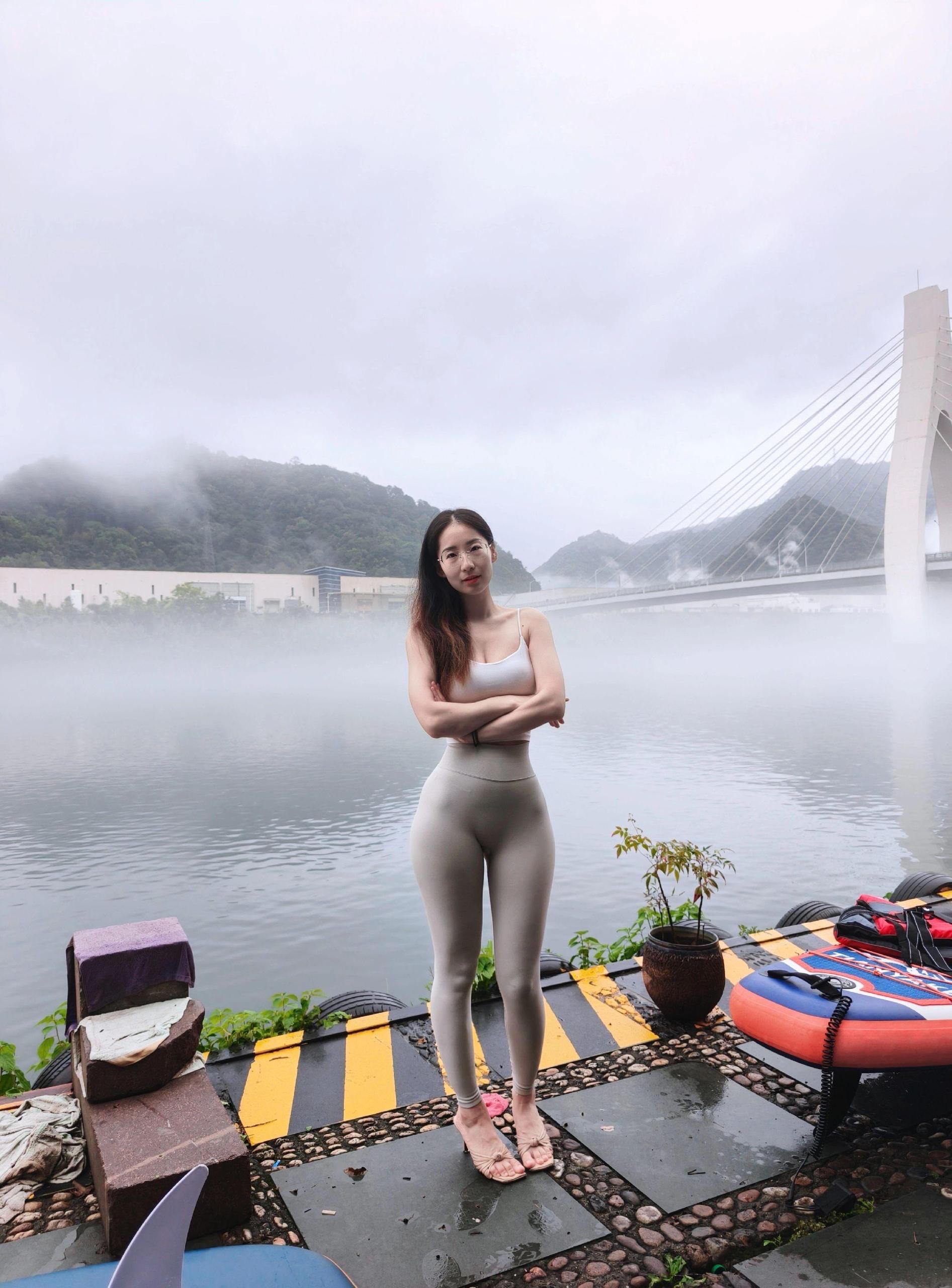 Phụ nữ yêu thể dục đang mặc trang phục quần tập yoga bên hồ nước