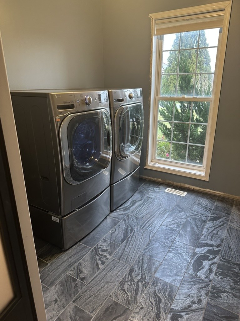 Finished laundry room with washer, dryer, and new floor