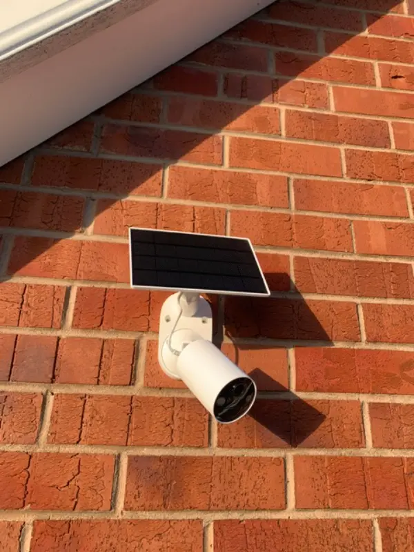 Outdoor PoE security camera being installed by a professional engineer using a drill