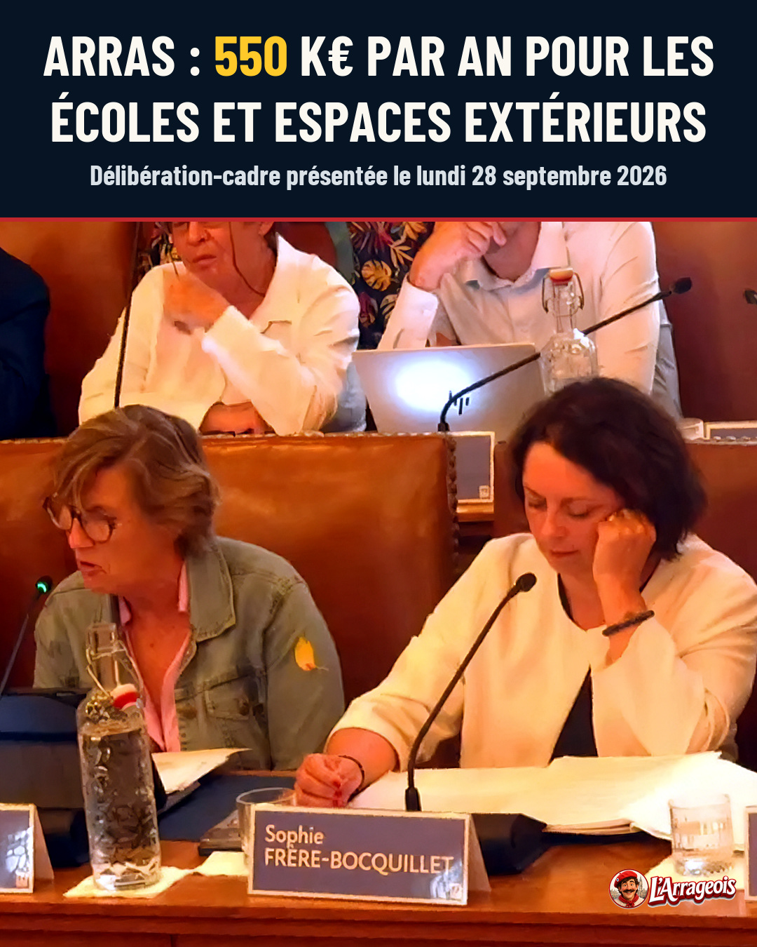 Des élus assis à une table avec micro et bouteilles d'eau pendant une réunion, l'un portant un badge nomm