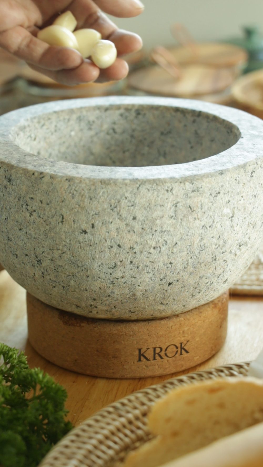 Adding garlic cloves to KROK granite mortar and pestle for Nam Jim seafood sauce