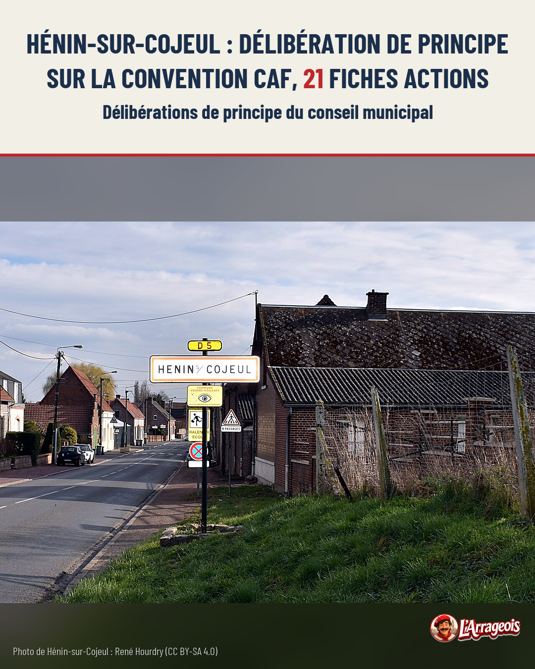 Une route de village bordée de maisons en brique, avec un panneau d'entrée Hénin-sur-Cojeul et des signalisations routières.