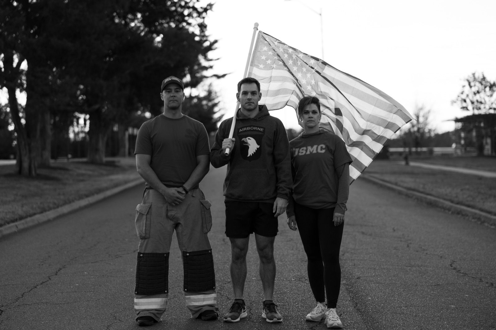Three participants standing with the flag