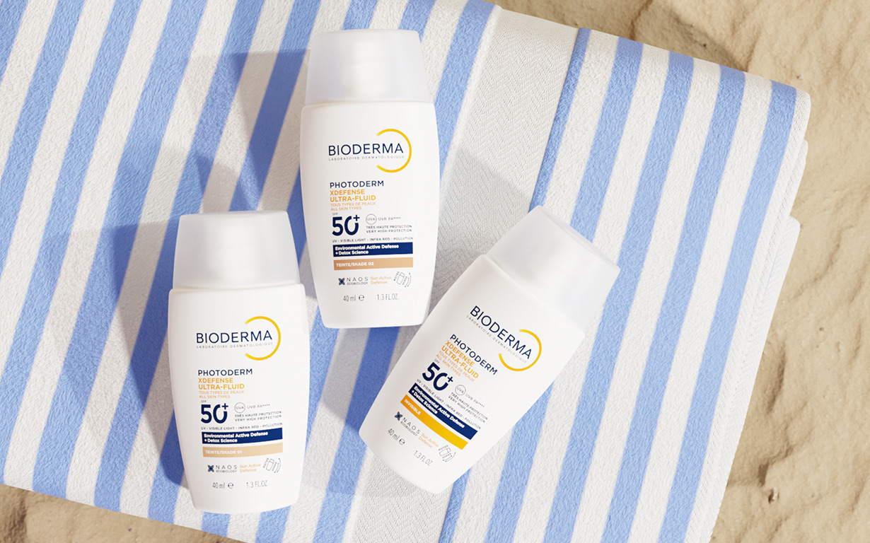 Photoderm XDefense Ultra-Fluid SPF50+ de Bioderma sobre una toalla de playa