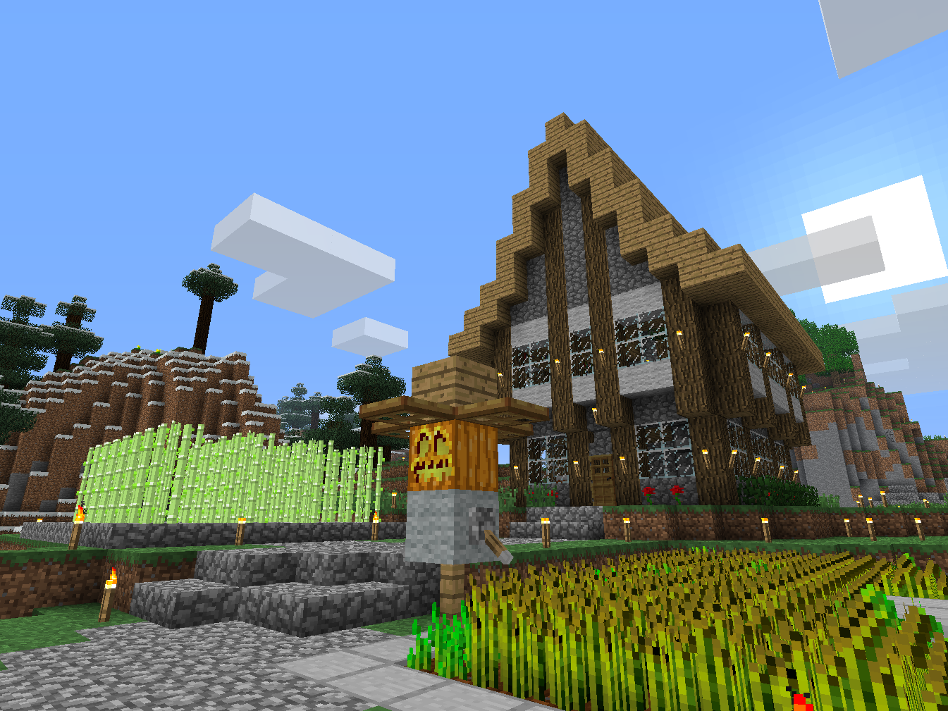 Screenshot of a two-storey medieval-looking house in Minecraft. There is a sugar cane farm and a wheat farm in the foreground, as well as a scarecrow.