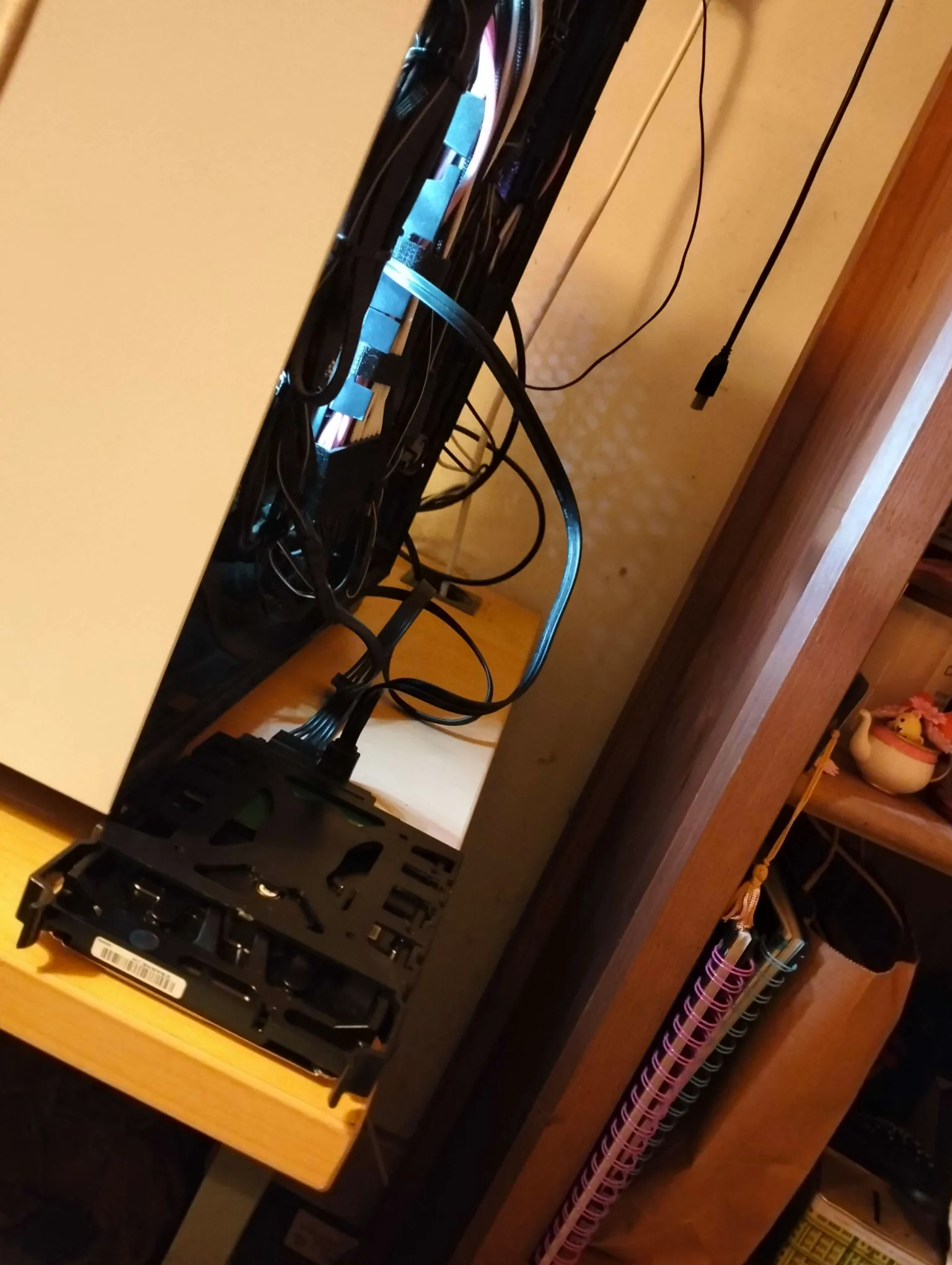A photo of the back of a PC. There is a HDD on the table, externally.