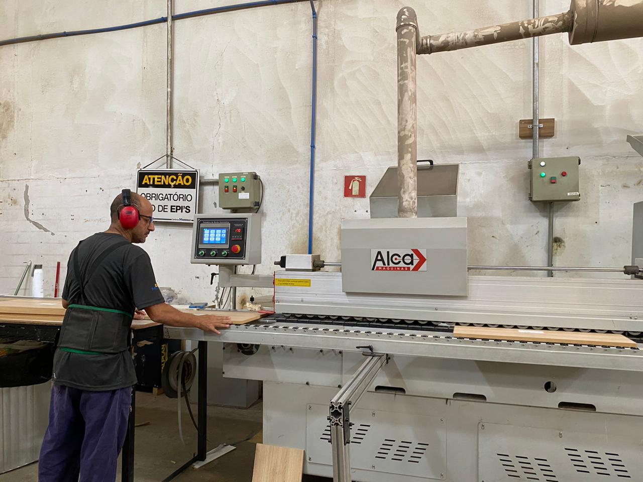 Operador da Disk Madeiras em máquina industrial com uso de EPI