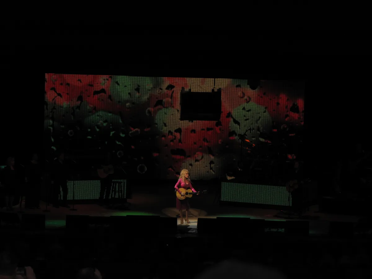 Dolly Parton performing with an acoustic guitar at Wolf Trap in 2011.