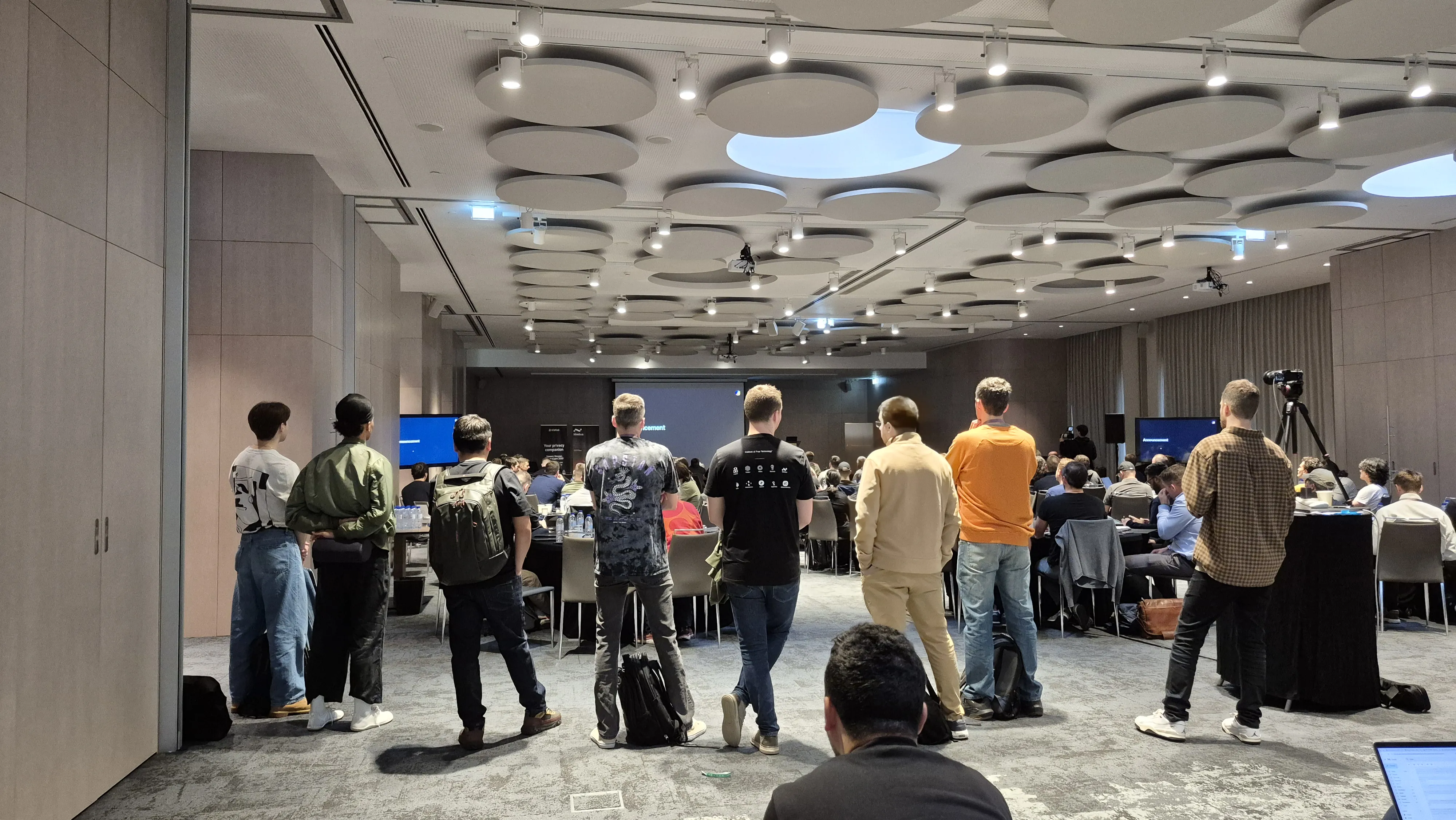 IFT attendees standing at the back of the room watching a session in Lisbon