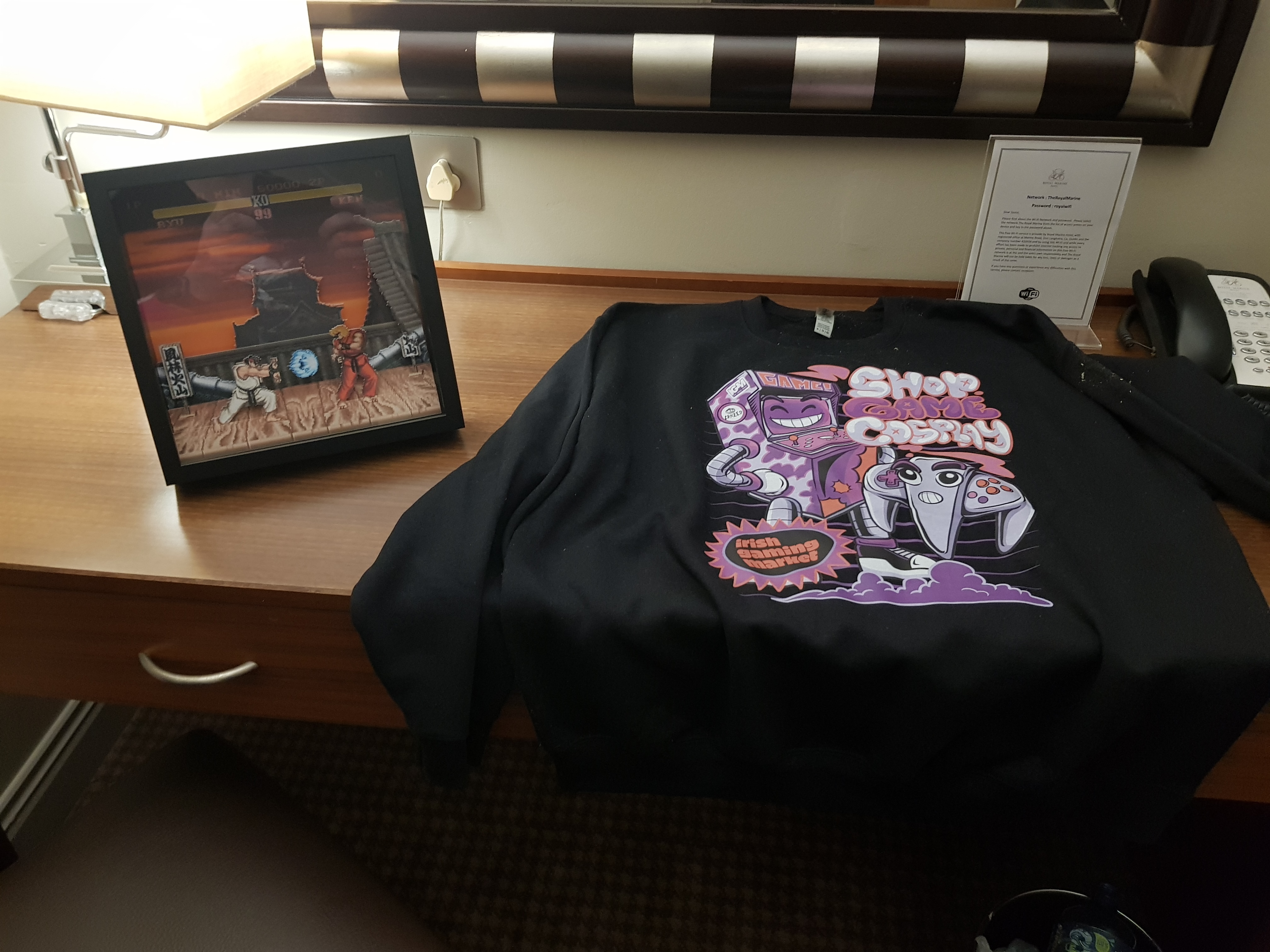 Left: a Street Fighter shadow box, depicting Ryu vs Ken in Street Fighter II. Right: the official IGM sweatshirt