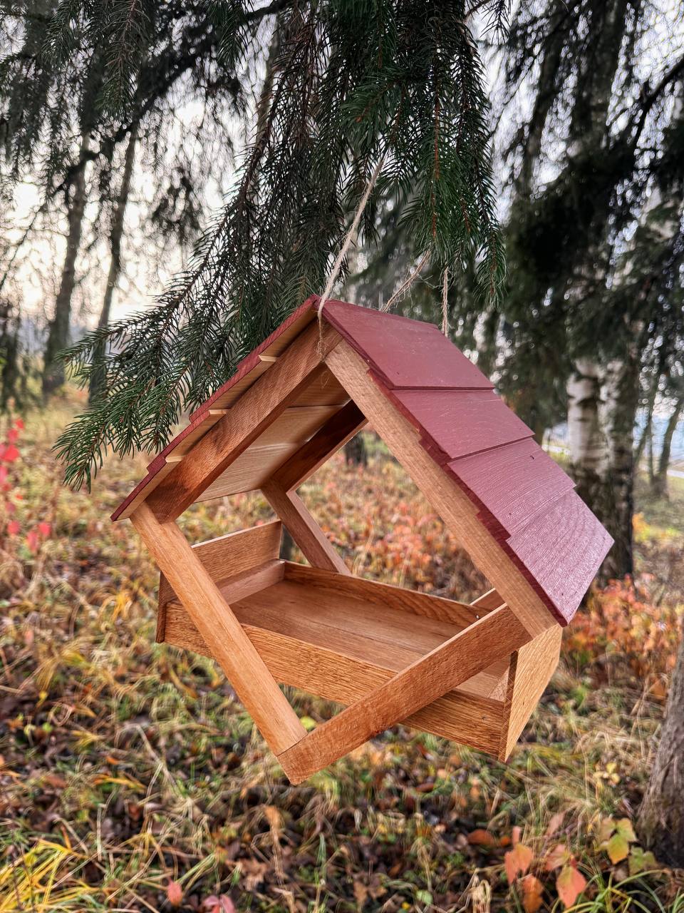 Майстер виготовляє дубову годівничку