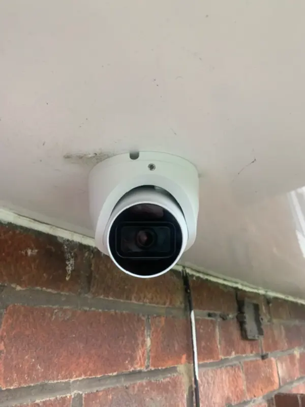 Bullet style CCTV camera mounted on brick wall with weatherproof housing