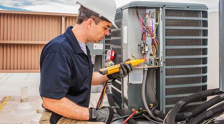 HVAC technician repairing an air conditioning unit