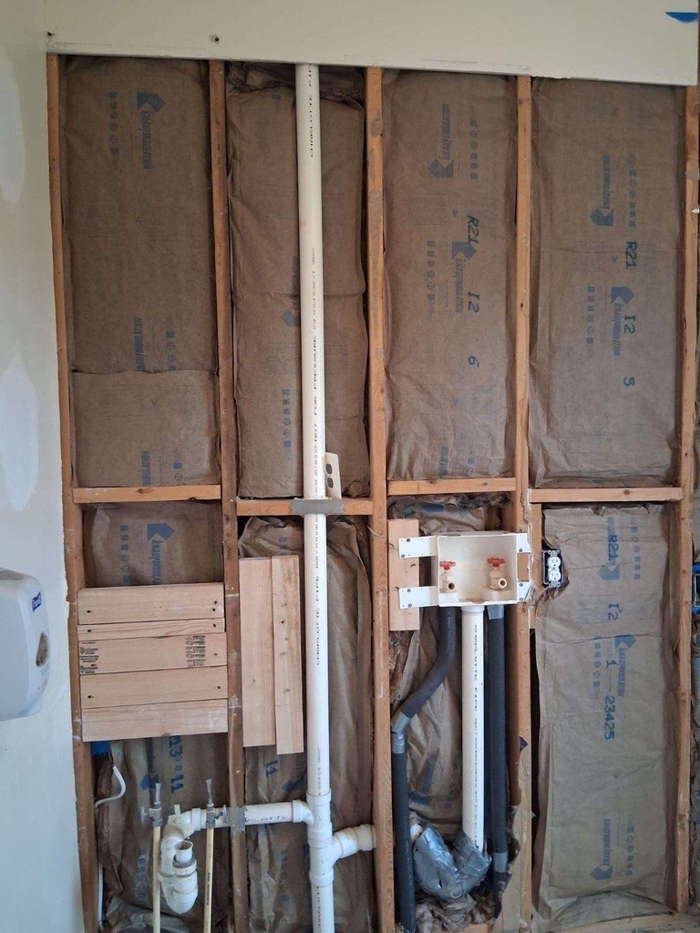 New plumbing in the opened laundry-room wall