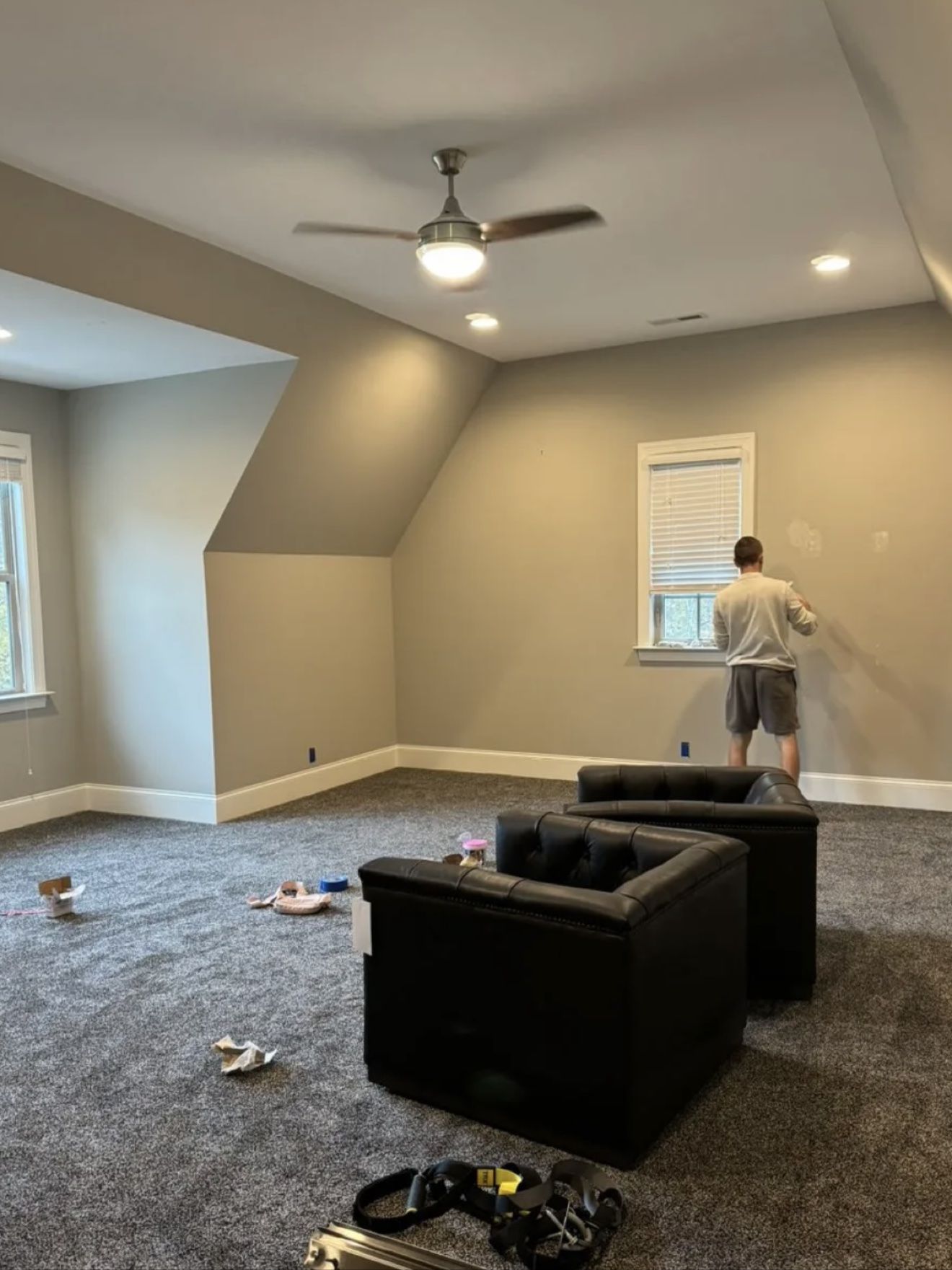 Aleh patching a wall in a large, freshly painted room