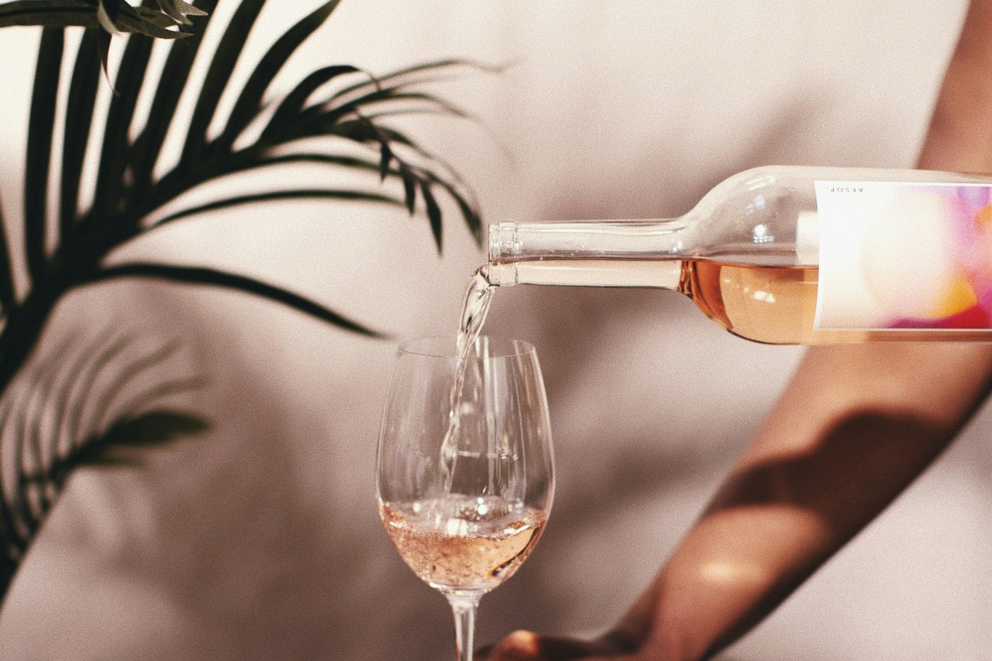 A person pouring rosé into one of two wine glasses during a tasting in Napa Valley.