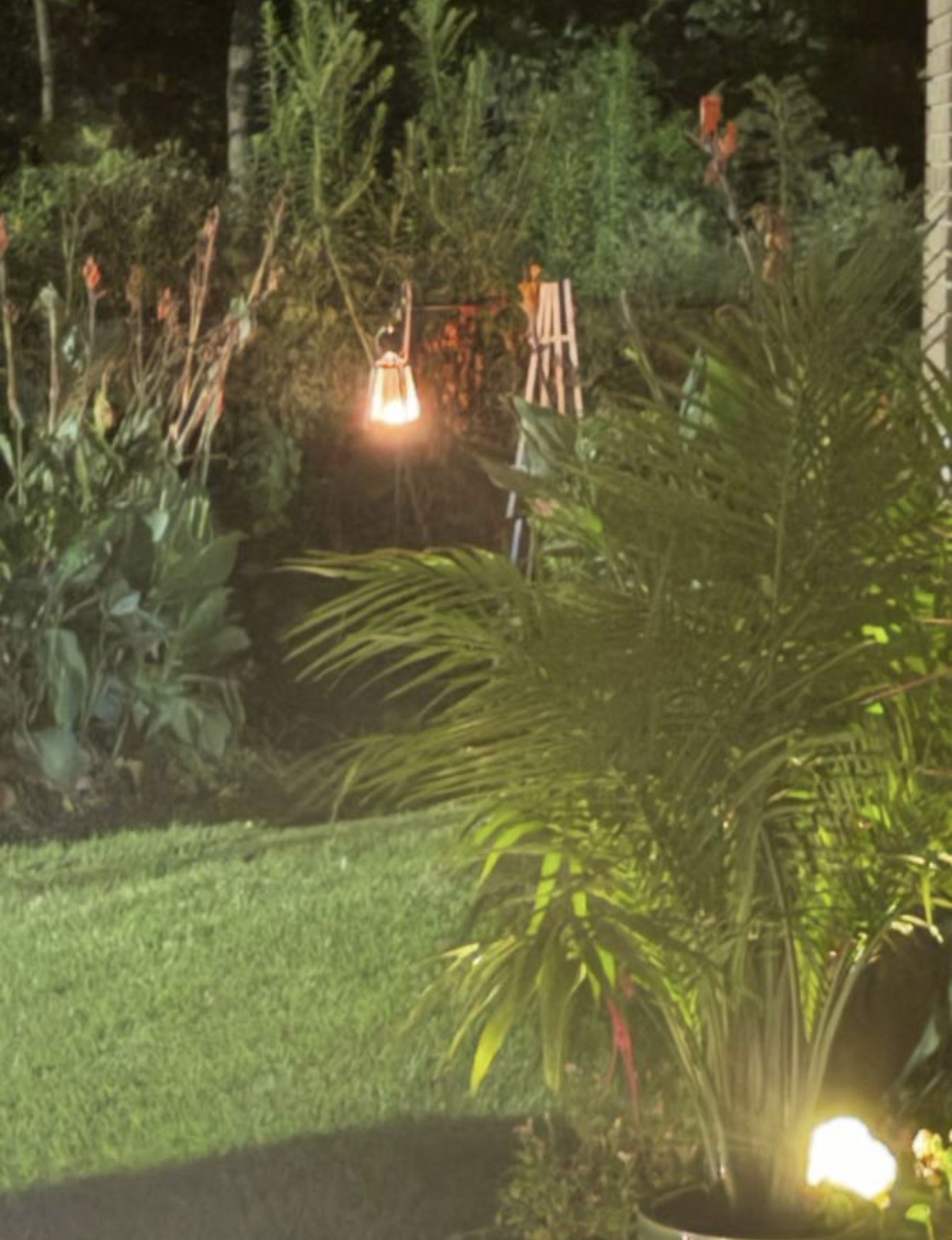 Lantern glowing on a porch table at night