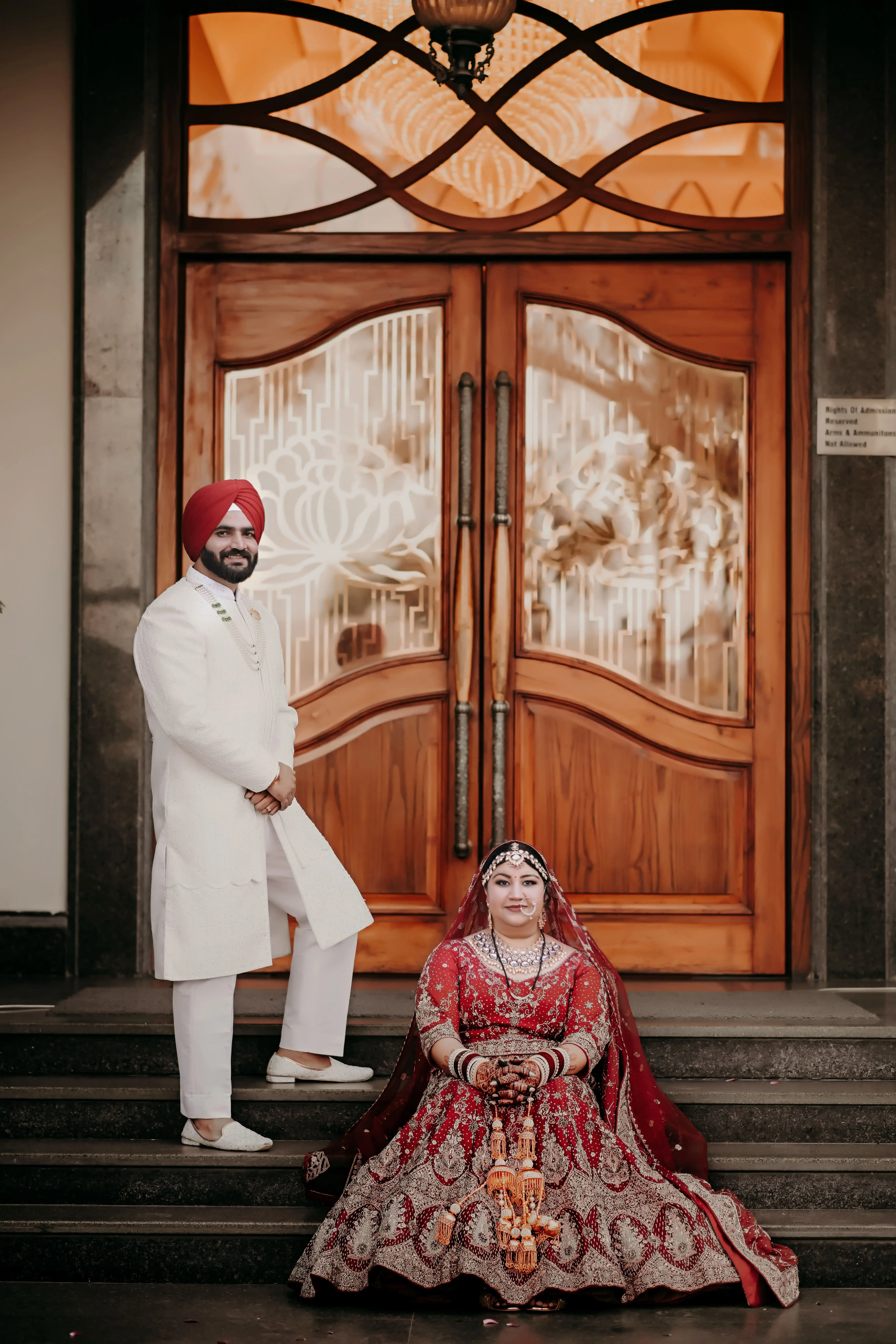 Best Wedding Photography in Ludhiana — elegant Indian bride and groom sharing a tender golden hour moment in a heritage palace courtyard with marigold garlands and warm string lights, captured by Helloweddingfilms professional wedding photographers