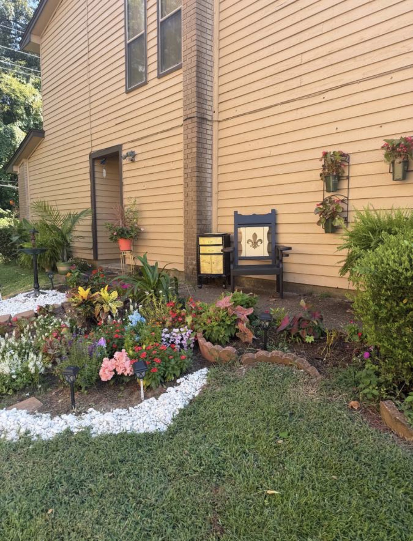 Finished flower bed in full bloom in front of the house