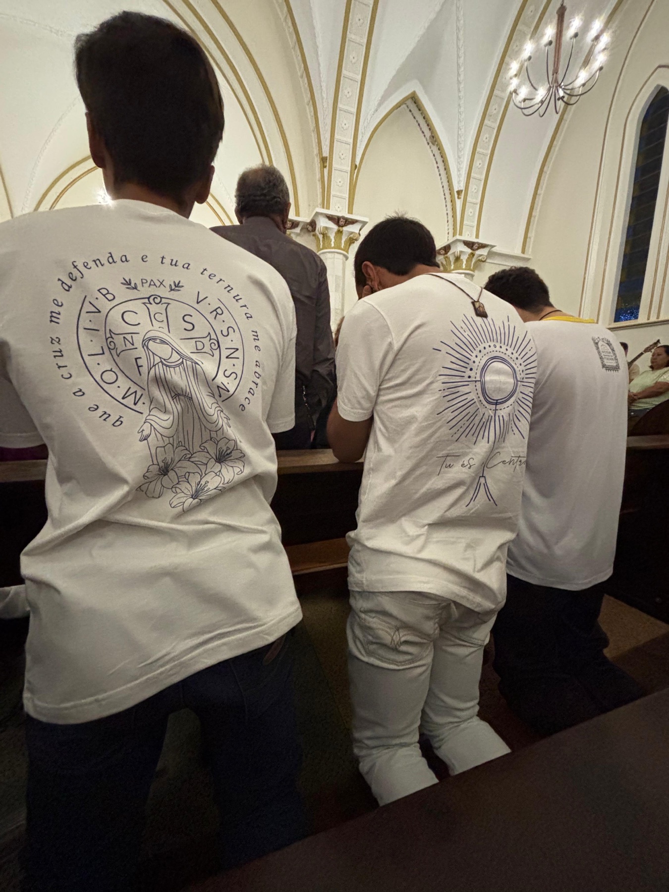 Clientes usando camisetas Manto e Cruz e Ostensório da HACE