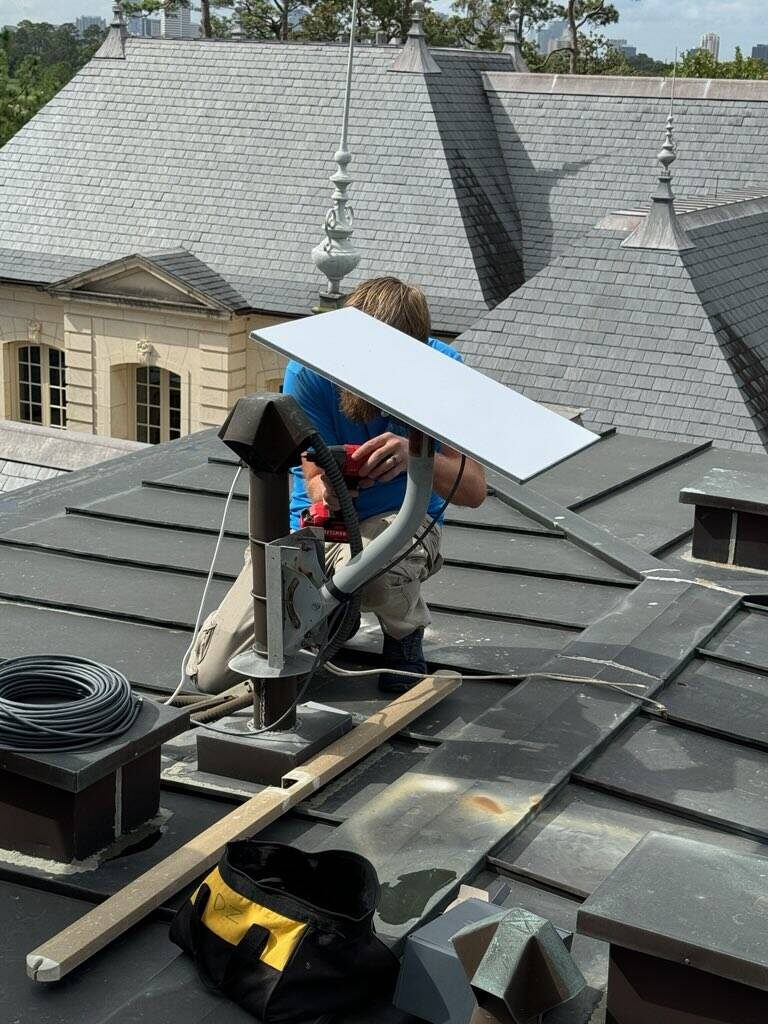 Dean installing a Starlink dish on a roof