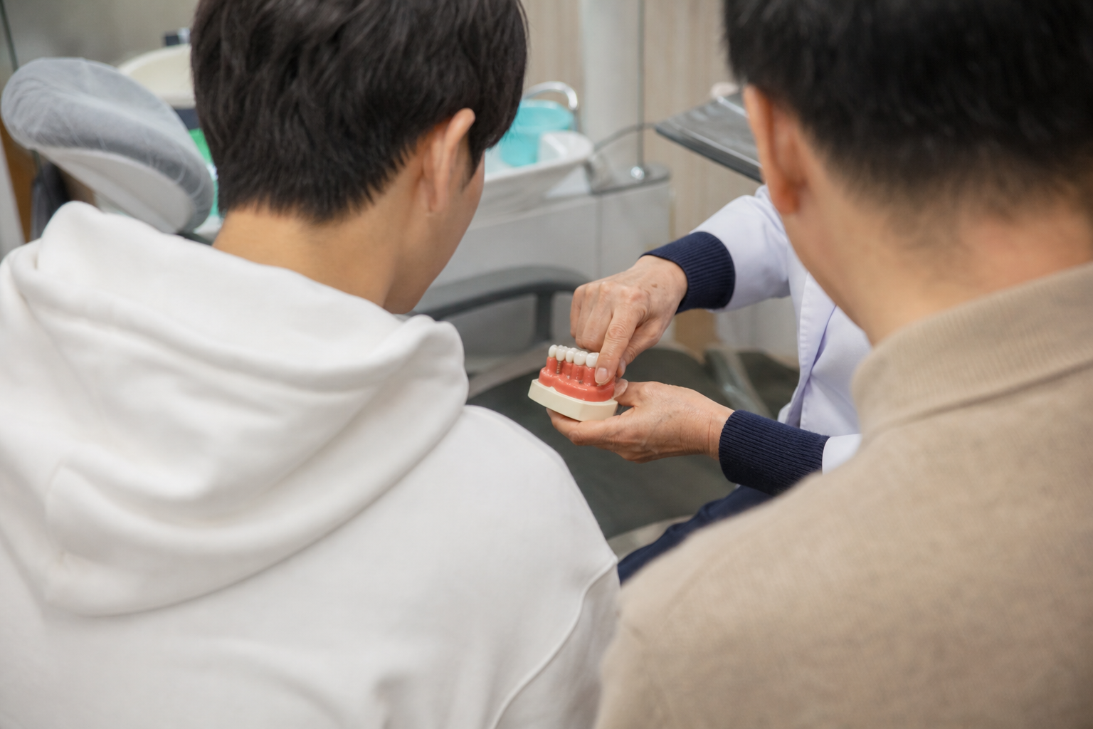 청소년 환자의 나이와 후속치료 필요 여부를 상담하는 치과 장면