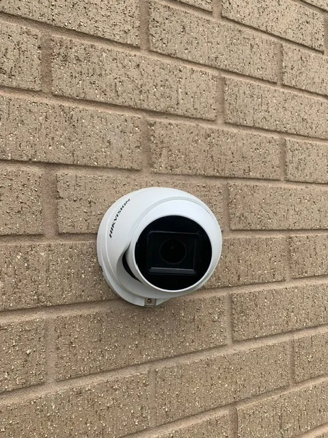 Bullet style CCTV camera mounted on brick wall with weatherproof housing