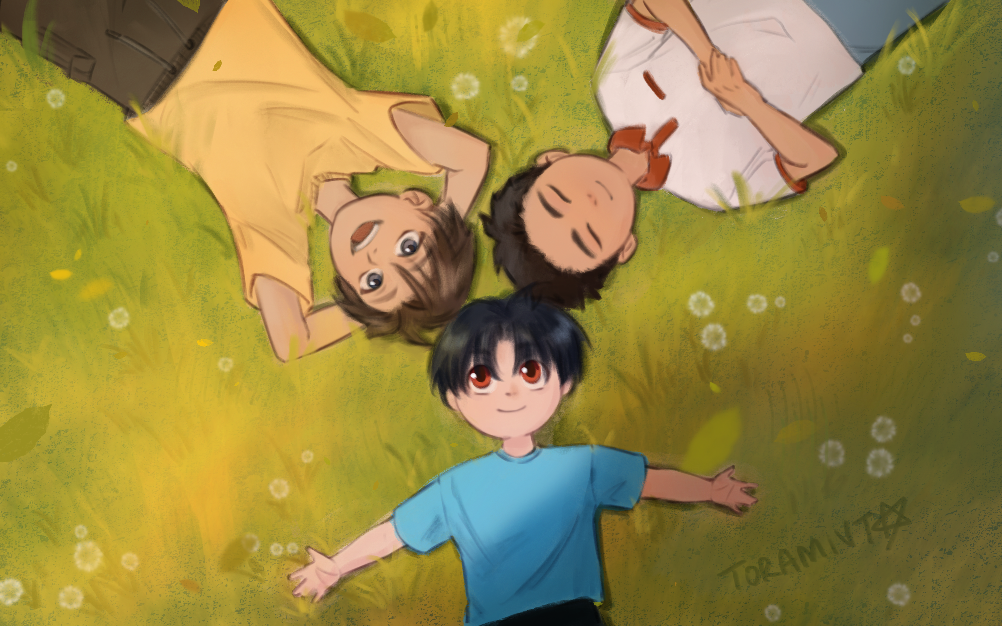 Three children laying in the grass. Their expressions are happy.