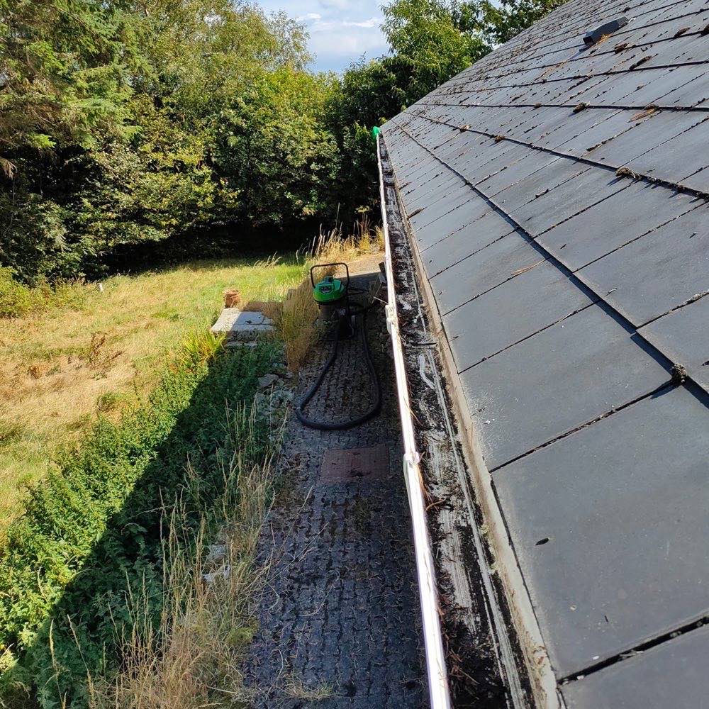Gutter vacuuming from a rooftop vantage point