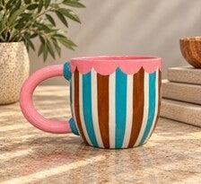 Hand-built mug with hand-painted striped details.