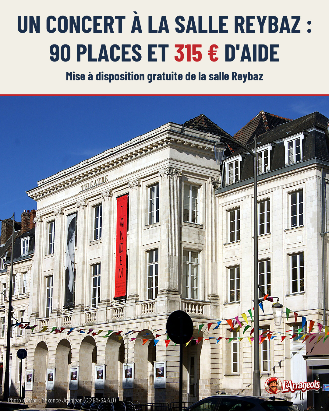 Façade blanche du théâtre Reybaz sous un ciel bleu, ornée de bannières publicitaires et de guirlandes colorées, avec des véhicules en bas.