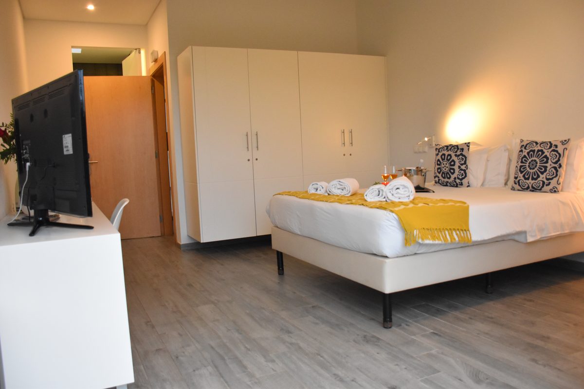 Quarto Duplo com Vista Serra — quarto com guarda-roupa e TV