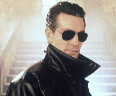 The Master as played by Eric Roberts, he is wearing sunglasses and a black leather coat.