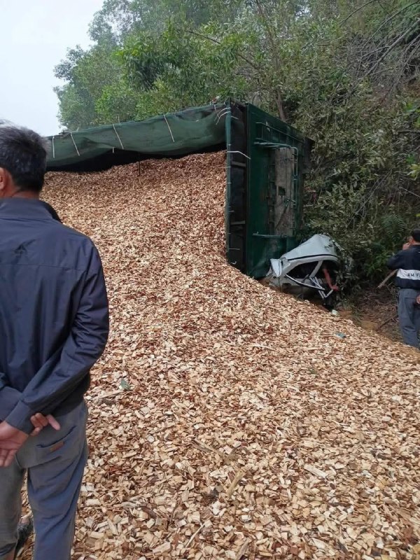 Xe tải lật nghiêng, dăm gỗ tràn ra đường