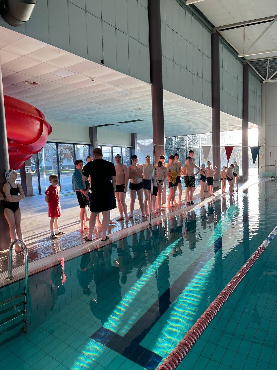 Bars Swim noored ujujad kuulavad treeneri juhiseid basseini ääres enne treeningut