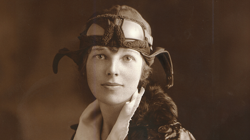 Amelia Earhart in flying cap and goggles in a historical portrait