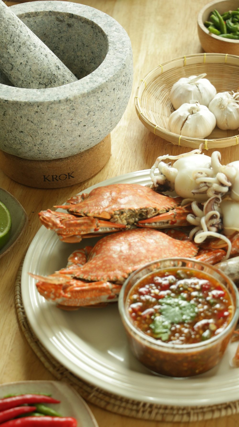 Nam Jim seafood sauce served with steamed crabs, shrimp, squid, and KROK mortar and pestle