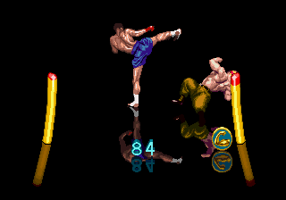 Dompayagen, a Muay Thai fighter wearing blue shorts, connects with a high kick on Garrison, a "self-taught martial artist" wearing a pair of greenish-brown trousers