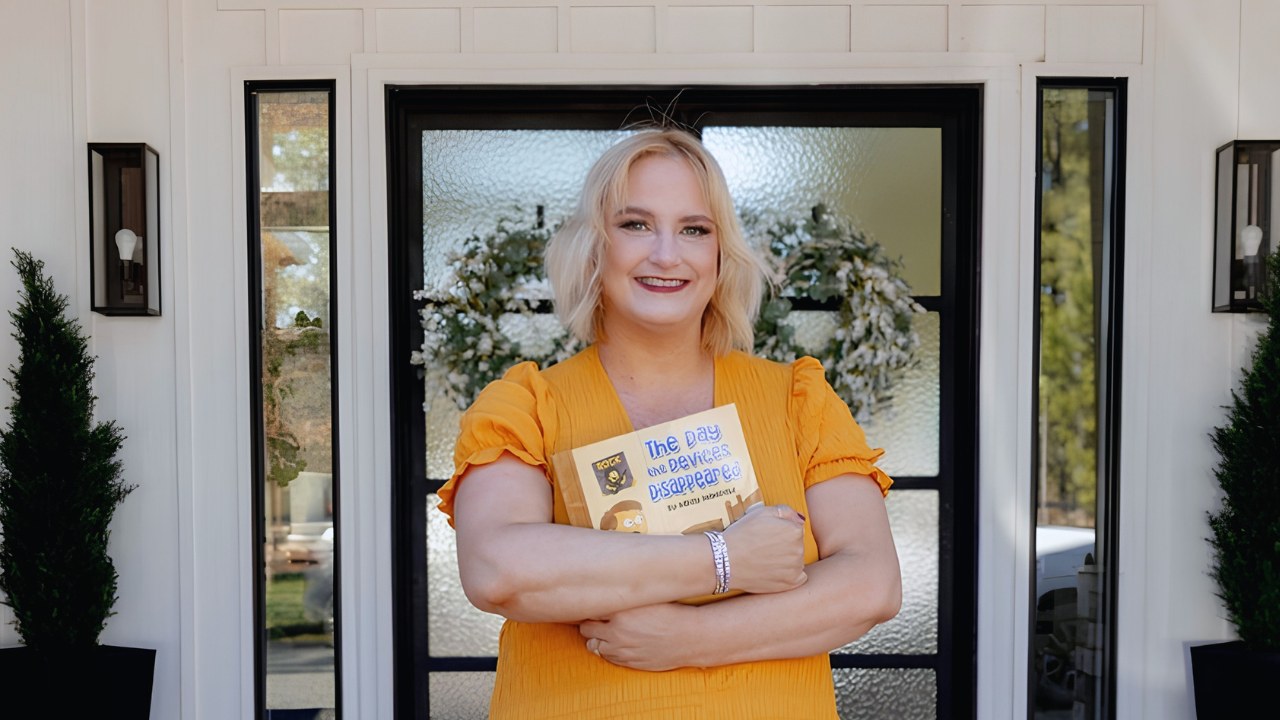 Author Kasey Mansfield holding her children's book The Day the Devices Disappeared