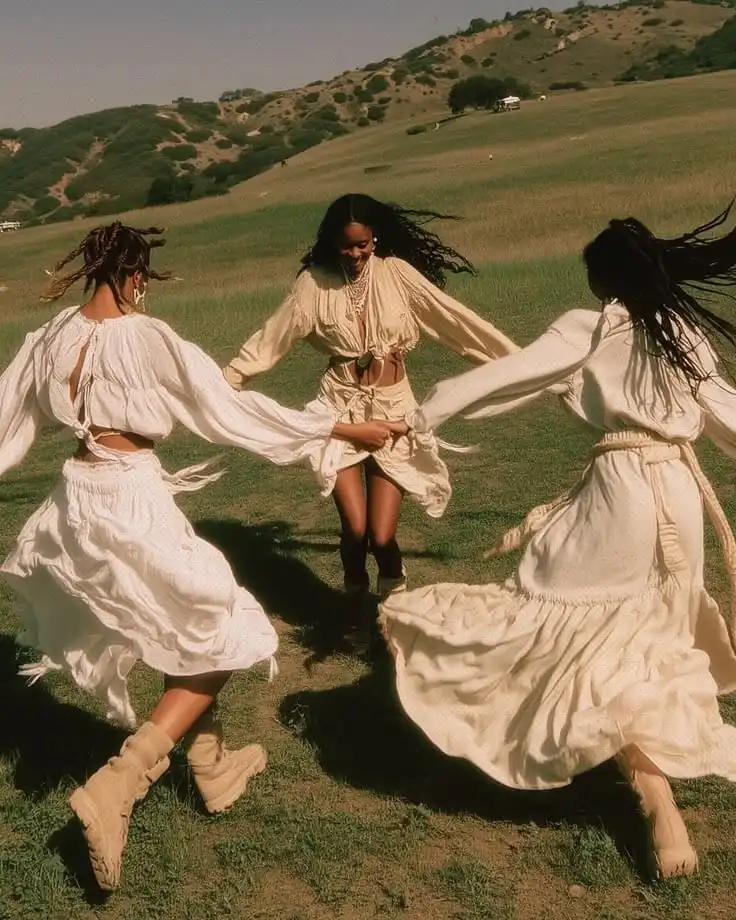 Doğada dans eden, beyaz kıyafetli üç kadın