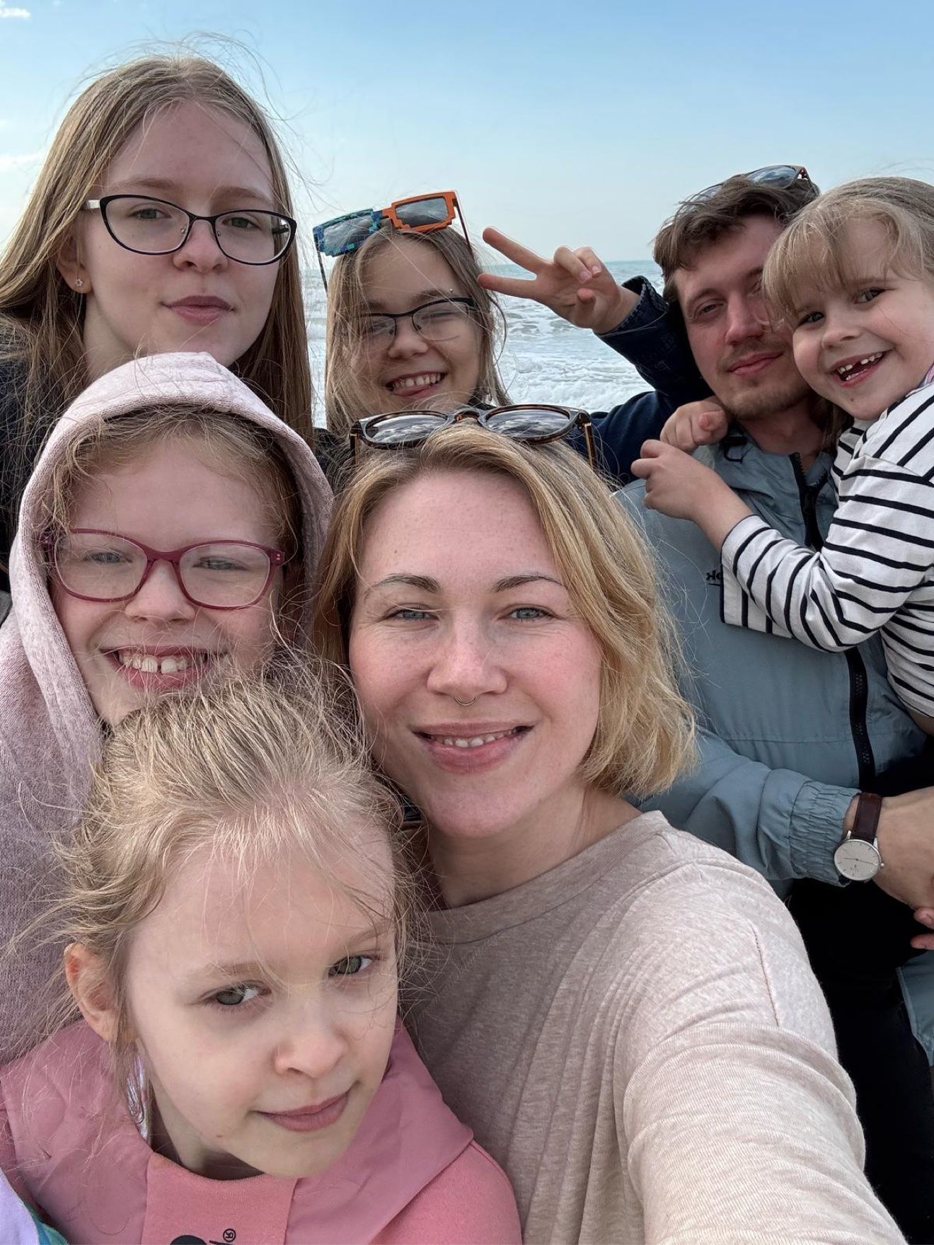 Masha and Aleh at the seaside with their five daughters, smiling into the camera
