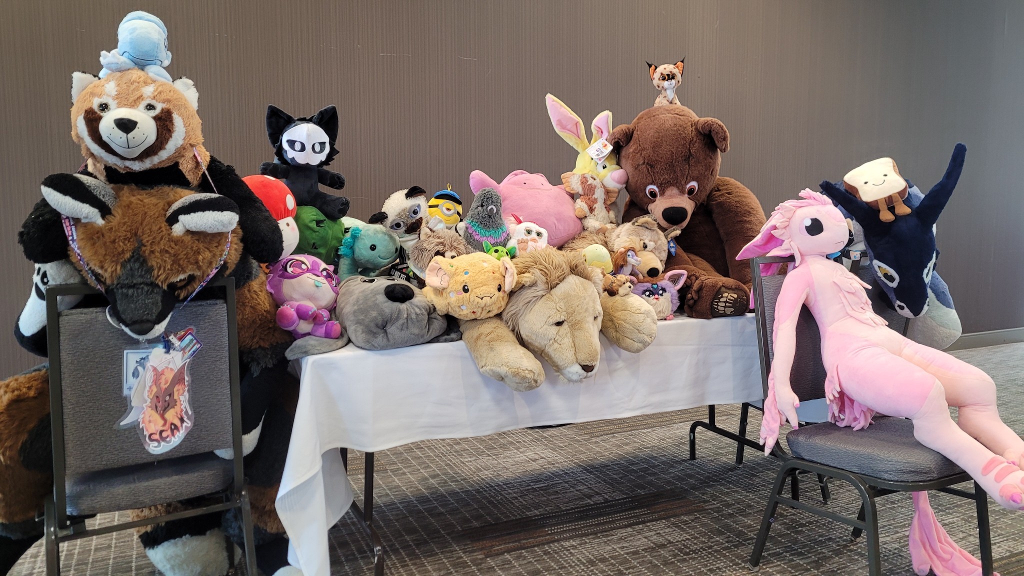 A table and several chairs covered in plushies