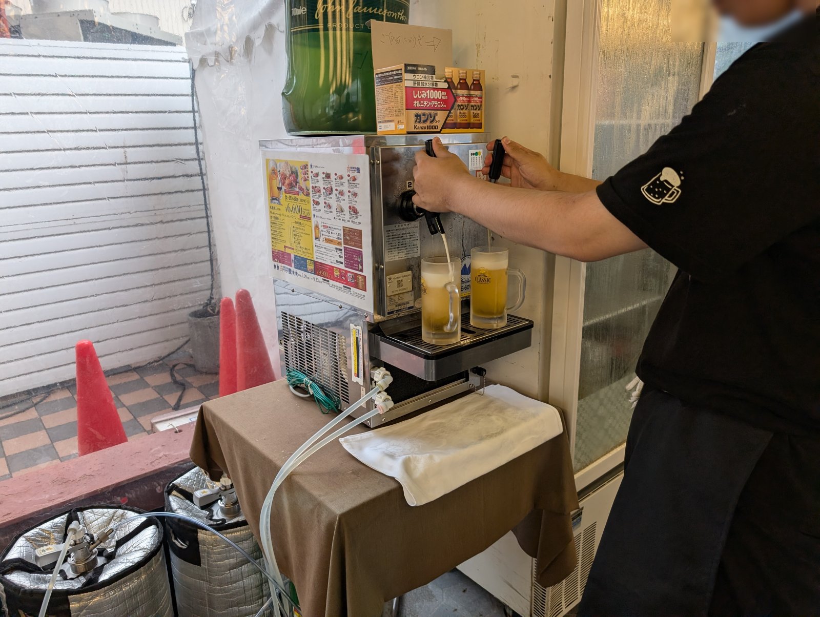 スタッフがビールサーバーからサッポロクラシックのウェルカムドリンクを注いでいる様子