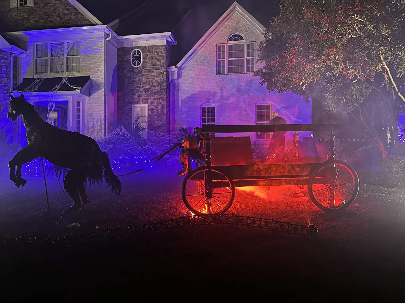 The hearse at night with horse, smoke, and lights